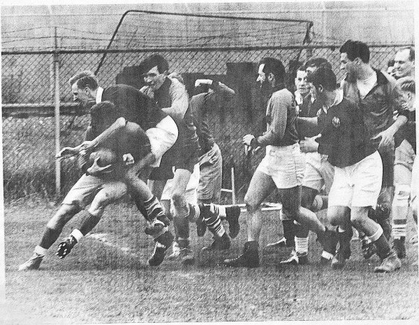 Baji Palkhiwala experiences a high tackle as Mike Burrows and Warren Sublette are near. Bert Sugar's face can be seen on the far right.