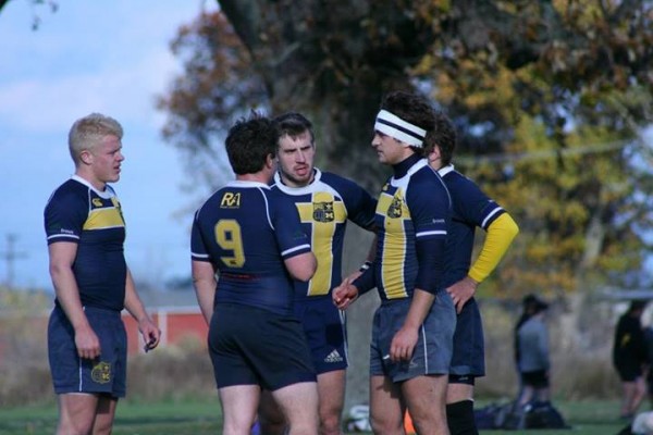 The backs discuss tactics during a break in play